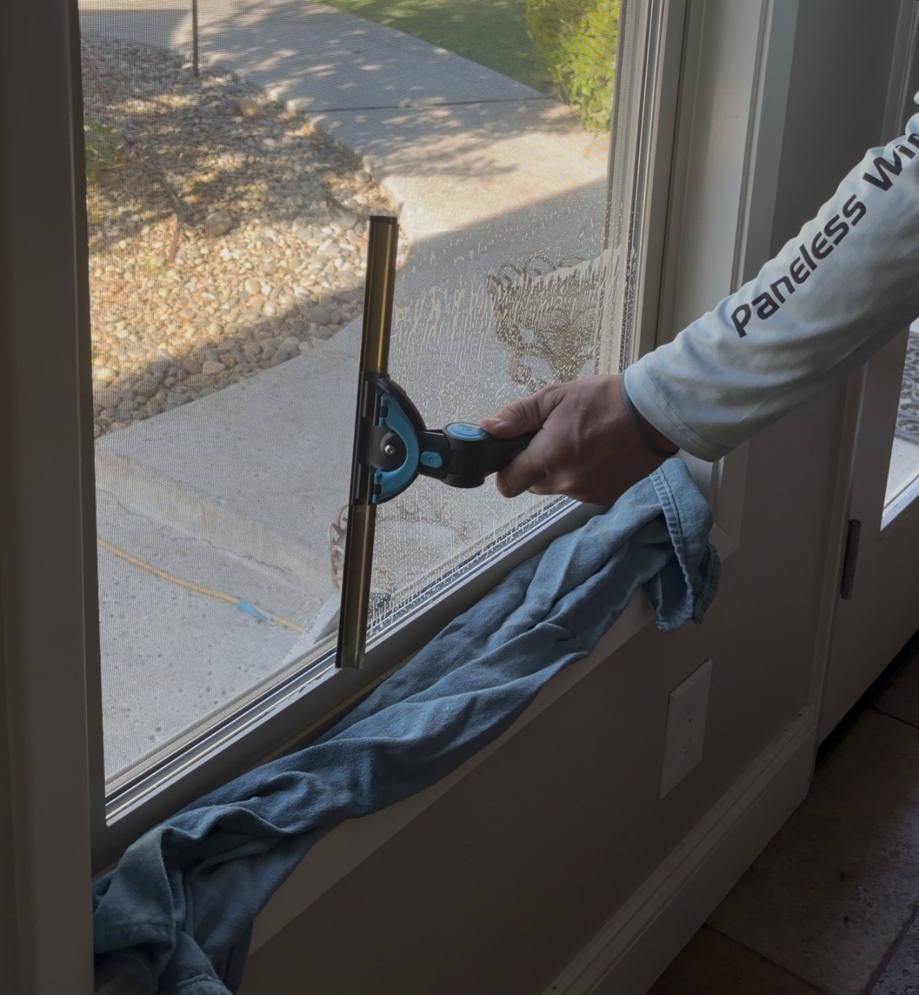 Paneless crew member squeegeeing an interior window